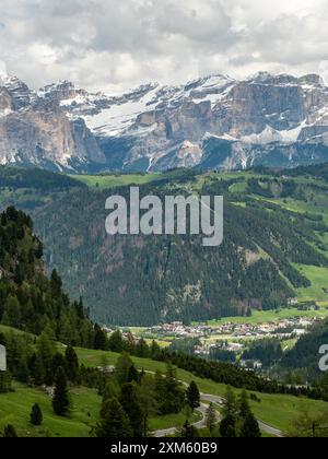 Genießen Sie einen Panoramablick auf Colfosco, umgeben von beeindruckenden Bergketten, die vom Wanderweg der Sella-Gruppe erfasst werden und den beeindruckenden G enthüllen Stockfoto