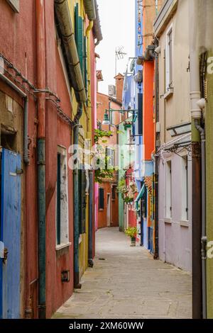 Die Straßen von Burano sind mit Häusern gesäumt, die in einem Spektrum von hellen Farben bemalt sind, die eine visuelle Note bieten, die Besucher verzaubert. Stockfoto