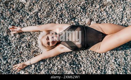 Frau in einem schwarzen Badeanzug am Pebble Beach Stockfoto