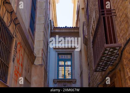 Barcelona, Spanien - 16. Juli 2024: Blick auf eine enge Passage in Barcelona mit markanter Architektur mit komplexen Details und farbenfroher Fassade Stockfoto