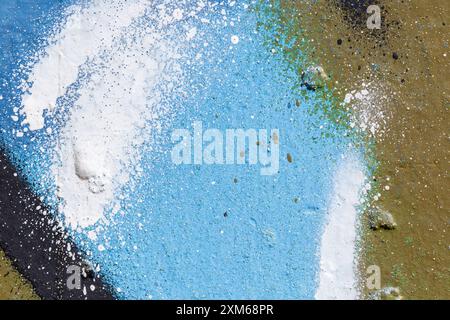 Makroaufnahme eines mit hellblau, schwarz, braun und weiß bemalten Wandsprays mit Spritzern. Abstrakter detaillierter strukturierter, spritzender Graffiti-Hintergrund. Stockfoto