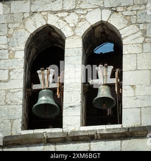 Zwei unverwechselbare Kirchenglocken, die durch Bogenfenster im Steinturm sichtbar sind. Auvergne. Frankreich Stockfoto