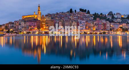 Ein 2:1-Panoramafoto eines Abends nach Sonnenuntergang in der farbenfrohen Stadt Menton, einer französischen Gemeinde und Stadt im Departement Alpes-Maritimes A Stockfoto