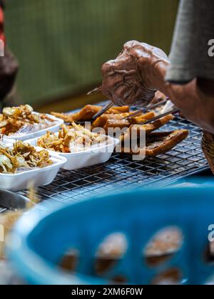 Street Food Vendor, Der Frittierte Snacks Serviert Stockfoto