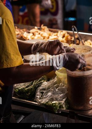 Ein Verkäufer bereitet auf einem Nachtmarkt Essen zu Stockfoto