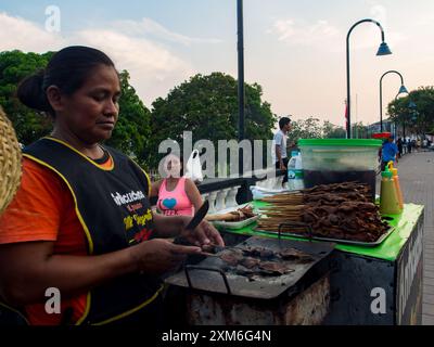 Iquitos, Peru - 22. September 2017: Frau kocht Roastbeef auf einem Stock auf dem Stab von Iquitos am Amazonasufer, Loreto, Peru, South am Stockfoto