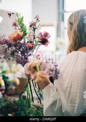Frau, die einen Blumenstrauß in einem Innenbereich hält Stockfoto