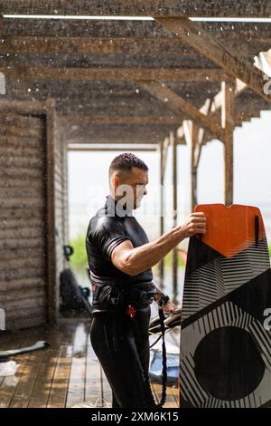 Ein Kitesurfer kommt nach dem Reiten mit seinem Drachen aus dem Wasser. Stockfoto