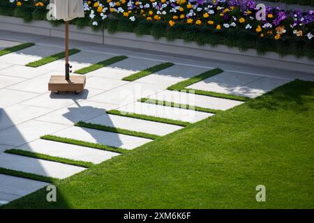 Schöne Steinterrasse in einem gepflegten Ziergarten Stockfoto