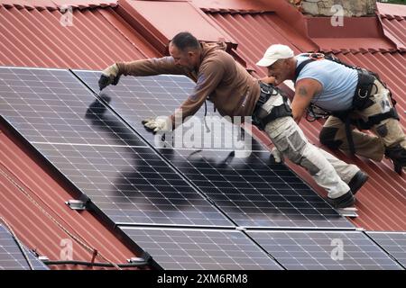 Zwei Arbeiter, Installation von Solarpaneelen auf dem Dach Stockfoto