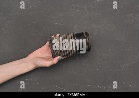 Die abgerissene Schutzabdeckung des Stoßdämpfers in der Hand Stockfoto