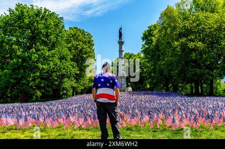 Boston, Massachusetts, USA – 24. Mai 2024: Ein amerikanischer Militärveteran, der vor siebenunddreißig amerikanischen Flaggen und den Soldaten und Segeln steht Stockfoto