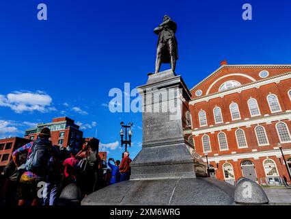 Boston, Massachusetts, USA - 13. August 2022: Aus einem niedrigen Winkel sehen Sie das Samuel Adams Monument (ca. 1880), Touristen und das Gebäude der Faneuil Hall (ca. 1743) Stockfoto