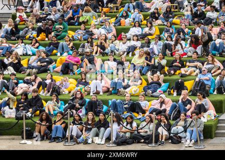 London, Großbritannien. Juli 2024. Die Leute sehen sich ein kostenloses Freiluftkino im Everyman on the Canal an, eine Großbildinstallation in Granary Square Steps, King's Cross, trotz des feuchten und wechselhaften Wetters heute, und scheinen ihren Sommer in der Stadtunterhaltung zu genießen. Everyman on the Canal zeigt täglich 4 Filme zwischen dem 1. Juli und dem 18. August. Quelle: Imageplotter/Alamy Live News Stockfoto