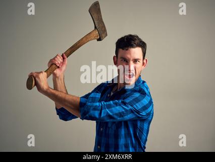 Wütend, Studio und Porträt eines Mannes mit Axt für aggressiven, schreienden und verärgerten Holzfäller. Schreiender, verrückter und feindlicher Holzfäller aus Kanada Stockfoto