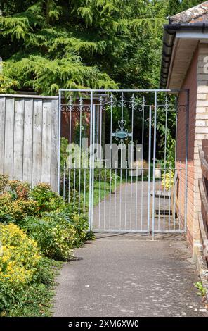 Attraktives dekoratives Tor/Tür aus Metall markiert eine klare Grenze am Eingang zum Garten eines Privathauses in Framlingham, einer Marktstadt in Suffolk. Stockfoto