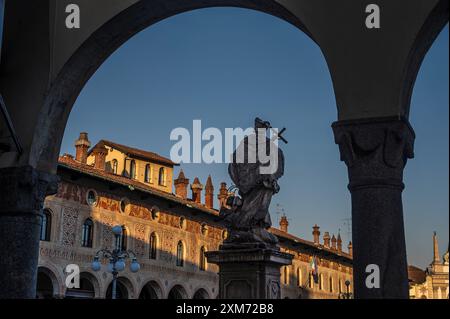 Blick durch Arkaden zur Piazza Ducale mit der Kathedrale von Vigevanono Cattedrale di Sant'Ambrogio am Ende des Platzes, Vigevano, Provinz Pav Stockfoto