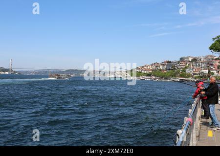 ISTANBUL, TÜRKEI-11.2022: Unbekannte Fischer fischen an der Küste von Uskudar am Leuchtturm Stockfoto