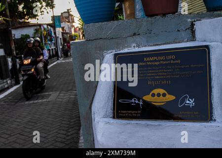 26. Juli 2024, Yogyakarta, Spezialregion Yogyakarta, Indonesien: Ein Motorradfahrer fährt durch das UFO-Dorf im Mantrijeron District, Yogyakarta City. Die Bewohner arbeiteten zusammen, um das Dorf mit einem UFO- und Alien-Thema zu dekorieren, um den Unabhängigkeitstag der Republik Indonesien am 17. August zu begrüßen. Darüber hinaus ist das UFO-Dorf als Sprache für das Studium des Universums gedacht, so dass die Menschen sich immer bewusst sind, in ihrer jeweiligen Umgebung Sauberkeit zu wahren. (Kreditbild: © Angga Budhiyanto/ZUMA Press Wire/Alamy Live News) NUR REDAKTIONELLE VERWENDUNG! Nicht für kommerzielle ZWECKE! Stockfoto