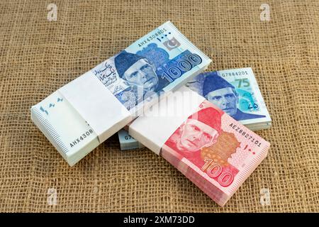 Verschiedene pakistanische Rupien-Banknoten auf Sackleinen-Oberfläche Stockfoto