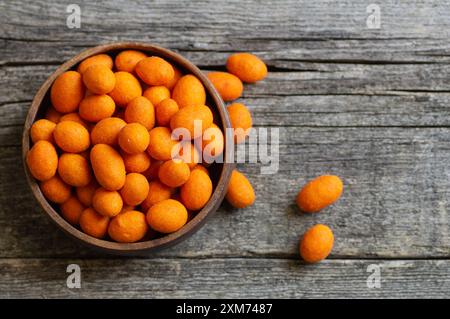 Erdnusschips mit Soße in einer Schüssel auf hölzernem Hintergrund, traditionelle gebratene Putennuss Stockfoto