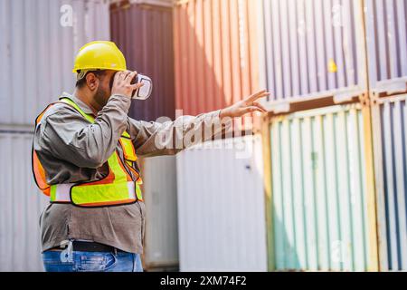 Mitarbeiter mit VR Vision Pro Technologie Headset-Gerät arbeiten auf der Baustelle Container Yard Innovation in der Logistikbranche Stockfoto