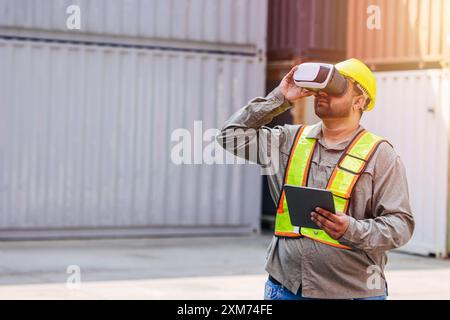 Mitarbeiter mit VR Vision Pro Technologie Headset-Gerät arbeiten auf der Baustelle Container Yard Innovation in der Logistikbranche Stockfoto