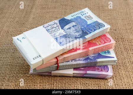 Pakistanische Banknoten stapeln sich auf einem Sackleinen-Hintergrund mit Kopierraum Stockfoto