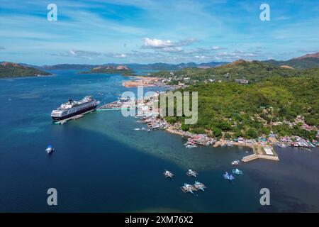 Luftaufnahme von Booten und Häusern entlang der Küste und Kreuzfahrtschiff Vasco da Gama (nicko-Kreuzfahrten) am Pier, Coron, Palawan, Philippinen Stockfoto