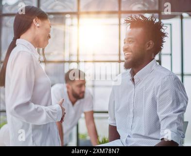 Business Handshake - Geschäftsleute schütteln die Hände. Händedruck zwischen Geschäftsmann und Frau in Innenräumen. Stockfoto