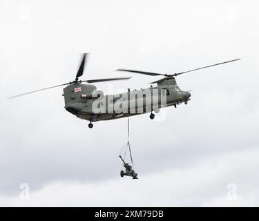 Ein Chinook-Hubschrauber der RAF Odiham transportiert ein Artillerieobjekt beim Royal International Air Tattoo 2024 Stockfoto