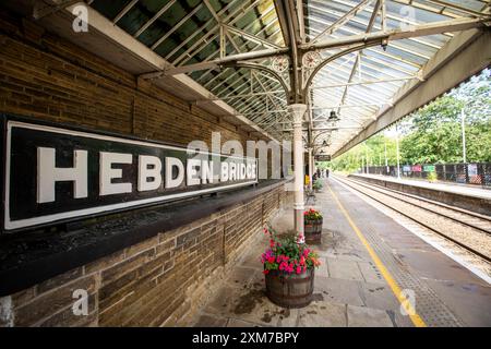 Der Bahnhof Hebden Bridge dient der Stadt Hebden Bridge in West Yorkshire, England. Der Bahnhof befindet sich an der Calder Valley Line, die seit April 2016 von Northern betrieben wird, von York und Leeds in Richtung Manchester Victoria und Preston. Die heutigen Gebäude stammen aus dem Jahr 1893, der Bau begann 1891.[3] zu diesem Zeitpunkt gab es neben dem Bahnhof einen Güterbahnhof. Der Bahnhof wurde 1966 geschlossen und ist heute ein Parkplatz. 1997 wurde der Bahnhof renoviert und Schilder im ursprünglichen Stil der Lancashire and Yorkshire Railway installiert. Quelle: Windmill Images/Alamy Live News Stockfoto