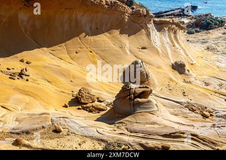 Faraklo, Lemnos, Griechenland: Faraklos vulkanische Felsformationen weisen auffällige gelbe und orangene Farbtöne auf und schaffen so eine unendliche Landschaft an der Küste Stockfoto