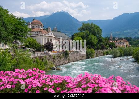 Meran, Südtirol, Italien - Kurhaus an der Passerpromenade in der Altstadt. Rosafarbene Blumen vor der Thermalbrücke. Stockfoto