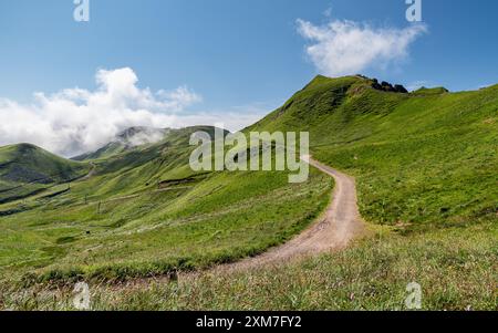 Natürlicher Pfad, der zum Puy de Sancy führt, dem höchsten Berg im Zentralmassiv. Wolken hängen vom Gipfel wie der Rauch eines Vulkans. Stockfoto