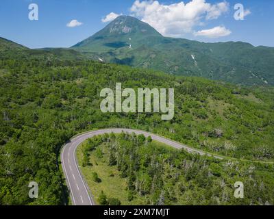 Rausu, Hokkaido: Scharfe Kurve entlang der Shiretoko Pass Straße mit dem Berg Rausu Vulkan im Shiretoko zwischen Utoro und Rausu am Sommertag in Jap Stockfoto