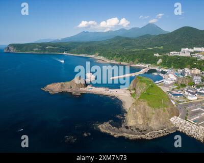 Utoro, Japan: Luftaufnahme eines Ausflugsbootes, das an einem sonnigen Sommertag in Hokkaido in Japan zurück zum Hafen von Utoro auf der Halbinsel Shiretoko segelt Stockfoto