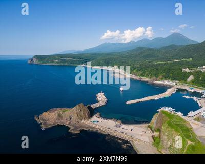 Utoro, Japan: Luftaufnahme eines Ausflugsbootes, das an einem sonnigen Sommertag in Hokkaido in Japan zurück zum Hafen von Utoro auf der Halbinsel Shiretoko segelt Stockfoto