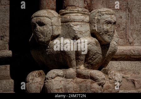 Zwei von drei in Marmor gestalteten Sitzfiguren an der Basis einer Säule in der Kathedrale in Trient, Italien. Die Figuren stellen vermutlich die Söhne von Maestro Adama d’Arogno dar, der Anfang der 1200er Jahre den Wiederaufbau der Kathedrale im romanisch-lombardischen Stil gemeistert hat Stockfoto