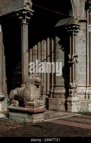 Der Löwe trägt die Säule am Südostportal zur Kathedrale in Trient, Italien, der Basilika di San Vigil. Auf der rechten Seite dieses Bildes befinden sich zwei von drei Sitzfiguren, die aus Marmor geformt sind. Die drei Figuren sollen die Söhne des Mannes darstellen, der Anfang der 1200er Jahre den Wiederaufbau der Kathedrale im romanisch-lombardischen Stil, Maestro Adama d’Arogno, gemeistert hat. Stockfoto