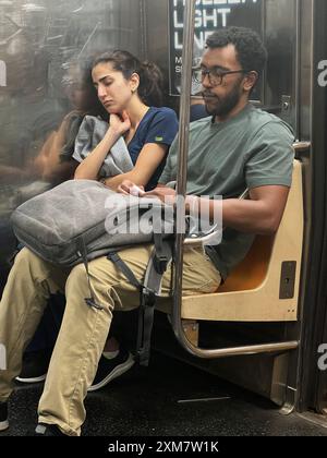 Müde Frau fährt nach einem Arbeitstag in New York City mit der U-Bahn. Stockfoto