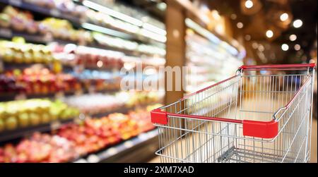 Supermarkt Lebensmittelgeschäft mit Obst- und Gemüseregalen innen defokussierter Hintergrund mit leerem roten Warenkorb Stockfoto