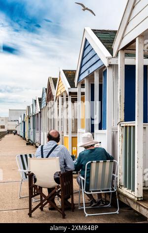 Ein Paar trinkt einen Cocktail vor einer Strandhütte in Southwold, Suffolk, Großbritannien. Konzepturlaub, englischer Sommer, englischer Urlaub, Meer. Stockfoto