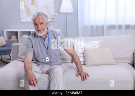 Senior Mann mit Notruftaste zu Hause Stockfoto