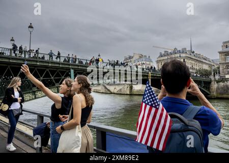 PARIS - Fans treffen sich am seine-Ufer vor der Eröffnungszeremonie der Olympischen Spiele in Paris. Zum ersten Mal in der Geschichte der Olympischen Sommerspiele findet die Eröffnungszeremonie nicht in einem Stadion statt, sondern an der seine. ANP REMKO DE WAAL Credit: ANP/Alamy Live News Stockfoto