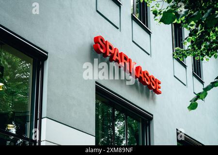 Sparkasse Gebäude mit rotem Schriftzug 16.07.24, Weimar: Symbolfoto, Illustrationsbild, Symbolbild, Illustrationsfoto, Alltagsszene Sparkasse Gebäude mit rotem Schriftzug das Bild zeigt ein Gebäude mit einem großen, roten Schriftzug SPARKASSE an der Außenwand, der auf eine bekannte deutsche Bankengruppe hinweist. Die Fassade des Gebäudes ist hell und glatt, mit mehreren Fenstern. Im oberen Bereich des Bilds sind grüne Blätter eines Baumes zu sehen, die Bild ein natürliches Element hinzufügen. Weimar Thüringen Deutschland *** Sparkasse mit roter Schrift 16 07 24, Weimar Symbol Foto, Stockfoto