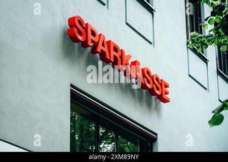 Sparkasse Gebäude mit rotem Schriftzug 16.07.24, Weimar: Symbolfoto, Illustrationsbild, Symbolbild, Illustrationsfoto, Alltagsszene Sparkasse Gebäude mit rotem Schriftzug das Bild zeigt ein Gebäude mit einem großen, roten Schriftzug SPARKASSE an der Außenwand, der auf eine bekannte deutsche Bankengruppe hinweist. Die Fassade des Gebäudes ist hell und glatt, mit mehreren Fenstern. Im oberen Bereich des Bilds sind grüne Blätter eines Baumes zu sehen, die Bild ein natürliches Element hinzufügen. Weimar Thüringen Deutschland *** Sparkasse mit roter Schrift 16 07 24, Weimar Symbol Foto, Stockfoto