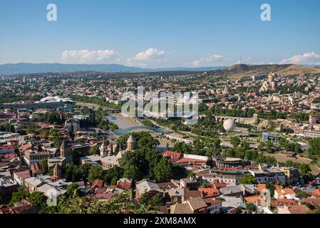Blick von der Aussichtsplattform von oben auf den Fluss Kura und die Sehenswürdigkeiten von Tiflis. Die städtische Landschaft. Der allgemeine Plan. Stockfoto