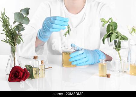 Aromatherapeutikum. Wissenschaftler, der ätherische Öle am weißen Tisch im Labor entwickelt, Nahaufnahme Stockfoto