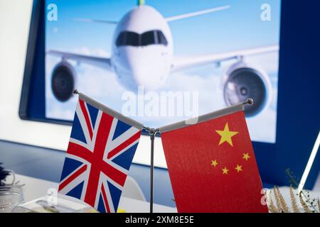 Eine Flagge der britischen Union Jack neben der chinesischen Nationalflagge auf der Ausstellung des chinesischen Regionaljets Comac während der Farnborough International Airshow am 26. Juli 2024 in Farnborough, England. Die diesjährige, halbjährliche Farnborough International Airshow bietet 1.500 Aussteller mit 100 000 m2 Ausstellungsfläche und über 80.000 Besuchern an den 5 Tagen. Stockfoto